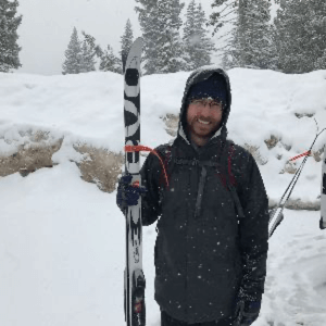 greg handy standing outside in snow holding skiis