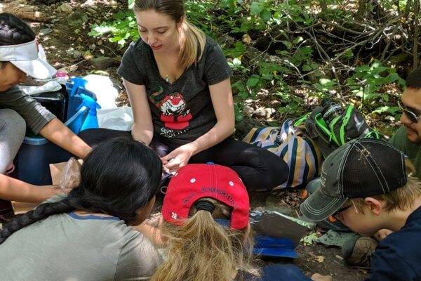 Ambassador with kids in a forested area