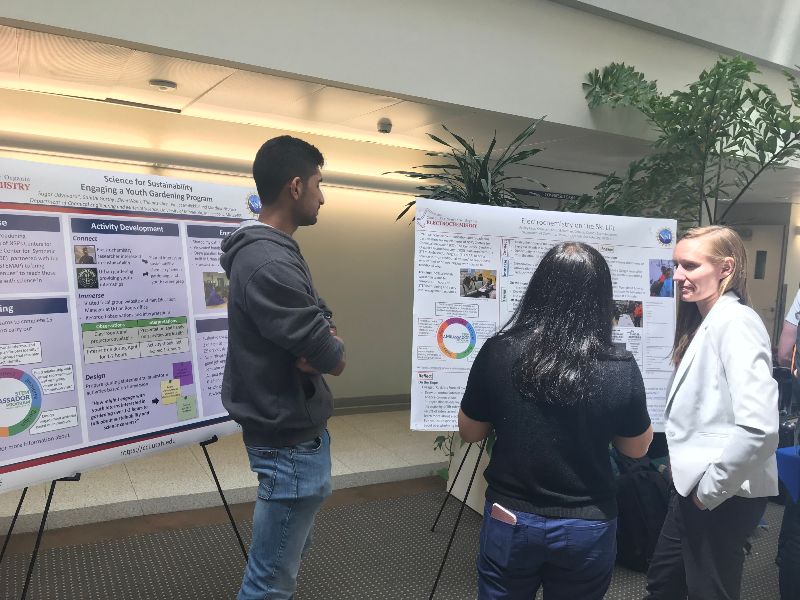 Ambassadors Sagar Udyavara (left) and Ashley Cass (far right) present posters about their public engagement of science experiences.