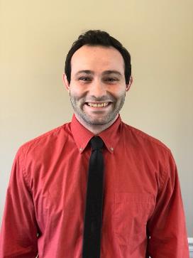 zach medcalf smiling wearing a red shirt and tie